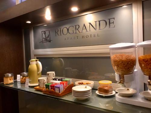 a restaurant counter with food on a table at Apart Hotel Rio Grande in Rosario