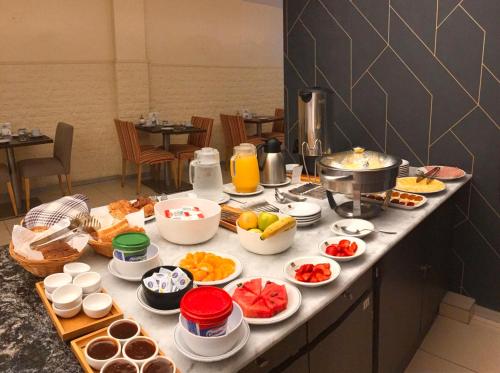 a breakfast table with fruits and vegetables on a counter at Apart Hotel Rio Grande in Rosario