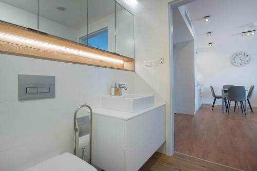 a white bathroom with a sink and a table at Apartament Premium PINEA 102 in Pobierowo