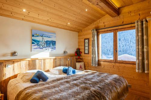 1 dormitorio con 1 cama grande en una cabaña en Chalet Coelacanthe, en La Clusaz