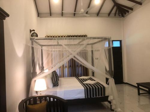 a bedroom with a bed with a canopy at skyresort in Tangalle