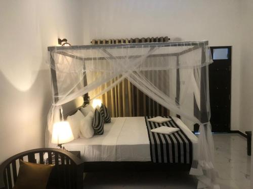 a bedroom with a bed with a canopy at skyresort in Tangalle