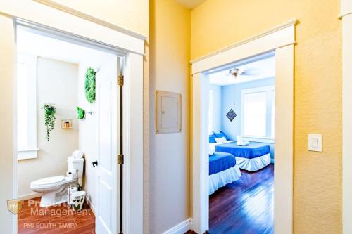La salle de bains est pourvue d'une porte s'ouvrant sur une chambre avec un lit. dans l'établissement Easy A - Flat in heart of N Hyde Park U of Tampa, à Tampa