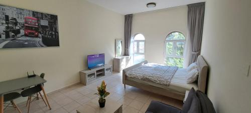 a bedroom with a bed and a desk and a television at DRUVYA HOLIDAY HOMES, Bld DG083, Street No,3 Discovery Gardens, Close to The Gardens Metro 6 minutes walkable in Dubai
