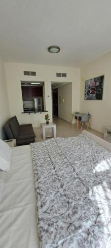 a bedroom with a large bed and a living room at DRUVYA HOLIDAY HOMES, Bld DG083, Street No,3 Discovery Gardens, Close to The Gardens Metro 6 minutes walkable in Dubai