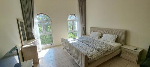 a bedroom with a bed and two windows at DG83 Studio flat, Close to The Gardens Metro station 5 min walkable in Dubai