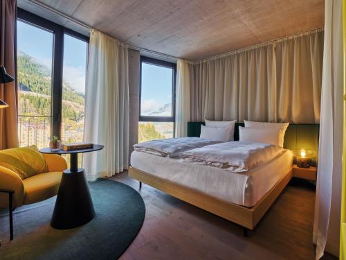a bedroom with a bed and a large window at Badeschloss in Bad Gastein