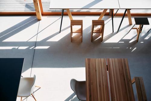a room with chairs and a table and shadows at ISHINOMAKI Home Base 石巻ホームベース in Watanoha