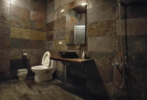 e bagno con servizi igienici, lavandino e doccia. di Bright Moon Homestay a Dongshi