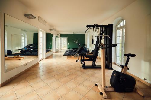 ahead burghotel في Lenzen: صالة ألعاب رياضية مع أجهزةٍ جري ودراجات ممارسة الرياضة في الغرفة