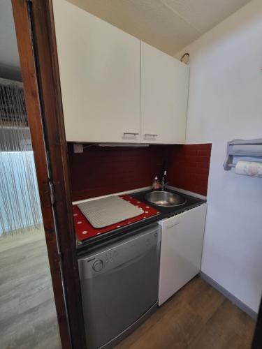 une petite cuisine avec un évier et une cuisinière dans l'établissement Les Mélèzes, à Saint-Chaffrey