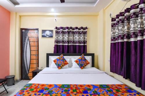 a bedroom with a large bed with purple curtains at Comfort Place in Salua
