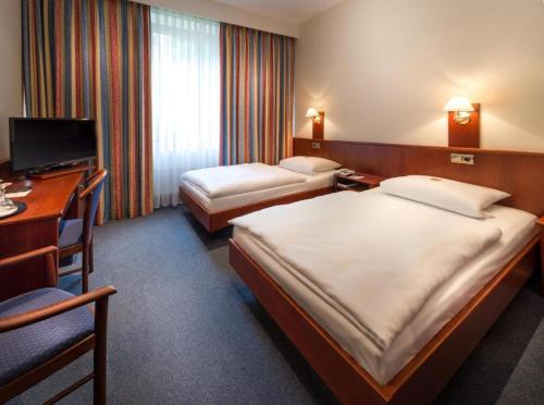 um quarto de hotel com duas camas e uma secretária em Hotel Alte Wache em Hamburgo
