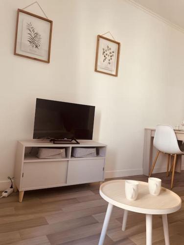 a living room with a tv and a table at Le Coin Cosy l Balcon in Castres