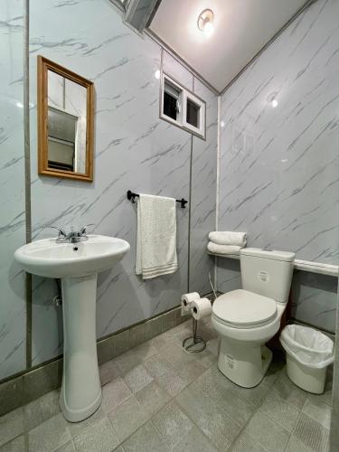 ein Badezimmer mit einem weißen WC und einem Waschbecken in der Unterkunft Paty’s house in San Pedro Sula
