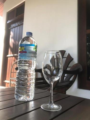 a bottle of water and a wine glass on a table at skyresort in Tangalle