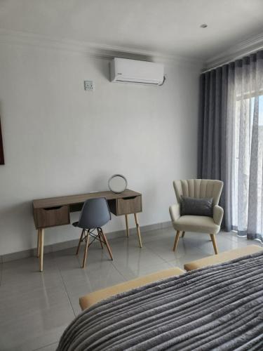 a bedroom with a desk and a chair and a bed at La Chambre Manor House in Nelspruit