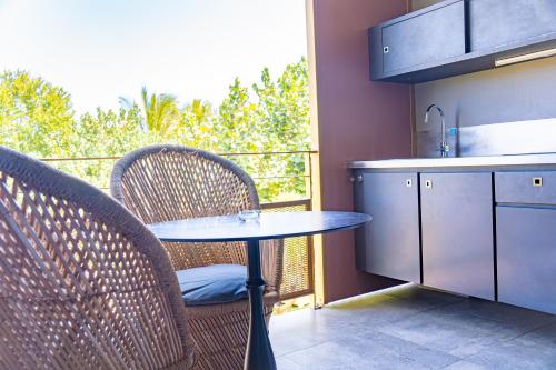 a kitchen with a table and chairs on a balcony at Dina Morgabine Saint Gilles in Saint-Gilles les Bains