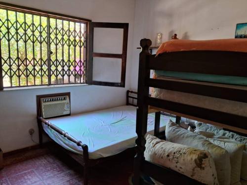 Habitación con 2 literas y ventana en Casa Excepcional em Jaconé com Ar e Piscina en Saquarema
