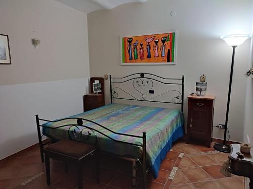 a bedroom with a bed and a picture on the wall at La Grotta del Leone in Potenza