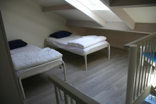 twee bedden in een kamer met een zolder bij Schorrebloem 9* in Nieuwvliet