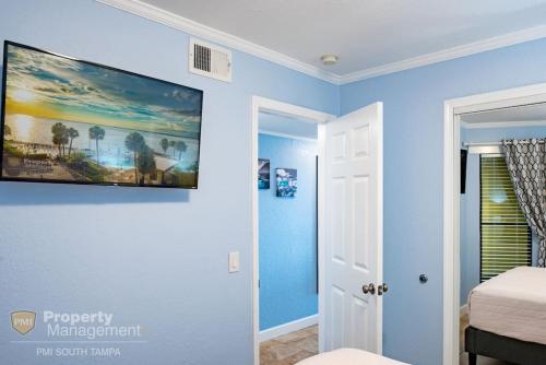 um quarto com paredes azuis e uma pintura na parede em Bay Dreamer em Tampa