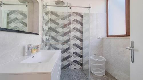 ein Bad mit einem Waschbecken und einer Glasdusche in der Unterkunft Doris Two in Novigrad Istria