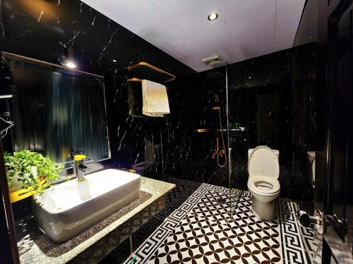 a black bathroom with a sink and a toilet at ROSA ZEN Hotel Spa in Ho Chi Minh City