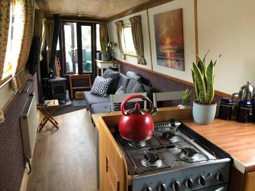 a kitchen with a stove with a tea kettle on it at Beautiful Narrowboat Glyndwr in Cambridge