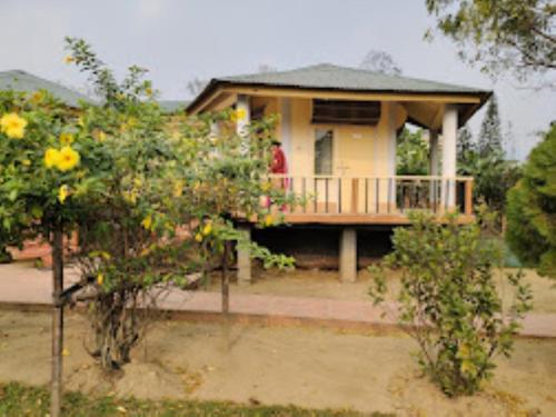 eine Person, die auf der Veranda eines Hauses steht in der Unterkunft Prashaanti Cottage Bhalukpong in Bhalukpung
