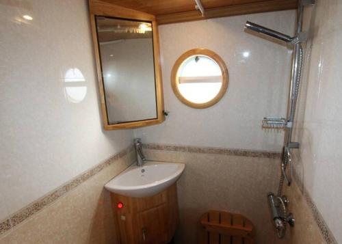 a bathroom with a sink and a mirror at Beautiful New Moon Narrowboat in Cambridge