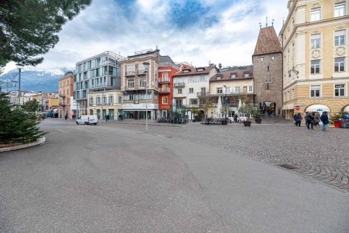a city street with buildings and people walking on the street at KERAMIK Suites in Merano
