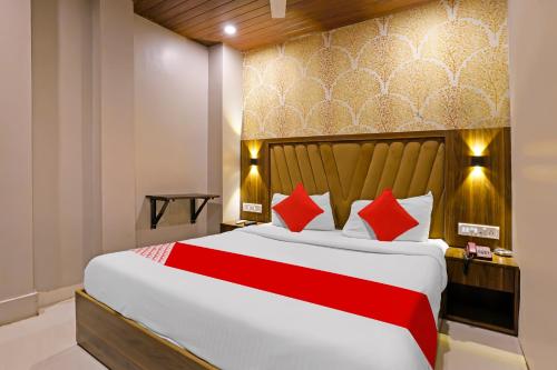a bedroom with a large bed with red pillows at OYO Hotel Homestay Near Chhatrapati Shivaji International Airport in Mumbai