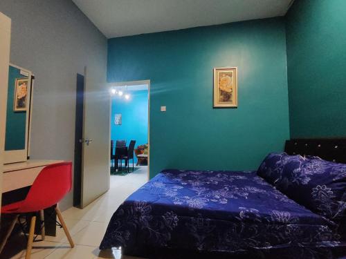 a bedroom with a bed and a table and a desk at Nanalacy Homestay ISLAM SAHAJA in Tanah Rata