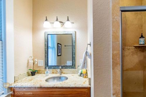 a bathroom with a sink and a mirror at Dead Poets Society- U of Tampa Flat in N Hyde Park in Tampa