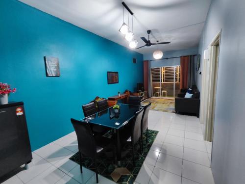 a dining room with blue walls and a table and chairs at Nanalacy Homestay ISLAM SAHAJA in Tanah Rata