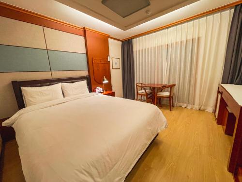 a hotel room with a large bed and a table at Hotel Terramar in Boryeong