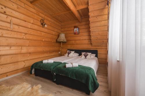 una camera con un letto in una cabina di legno di Wilczkowe Izby a Leśnica