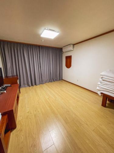 a large room with a wooden floor and a table and a desk at Hotel Terramar in Boryeong