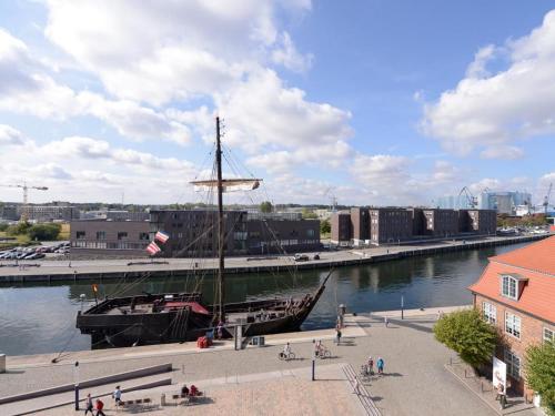 una barca attraccata a un molo in un fiume di Ohlerich Speicher App_ 25 a Wismar