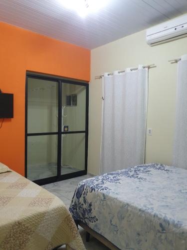 1 dormitorio con 1 cama y puerta de cristal en Diária em Família, en Natal