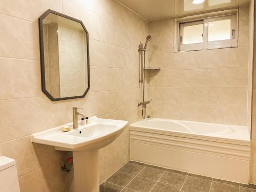 a bathroom with a sink and a bath tub at Hotel Terramar in Boryeong