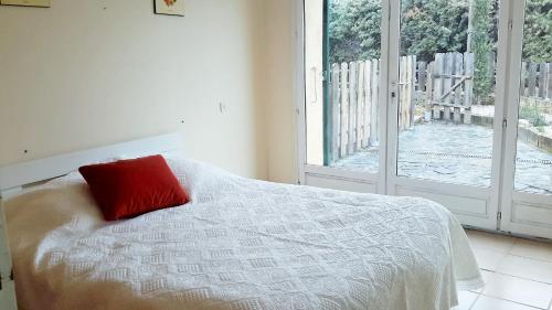 - une chambre avec un lit doté d'un oreiller rouge dans l'établissement Entre mer et montagne, à La Roque-dʼAnthéron