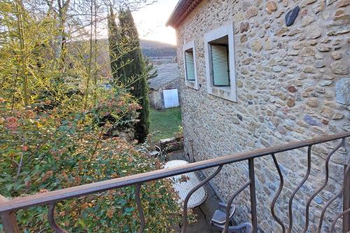 a balcony of a stone building with a window at Maison Pierres Bois Feuilles in Alzon