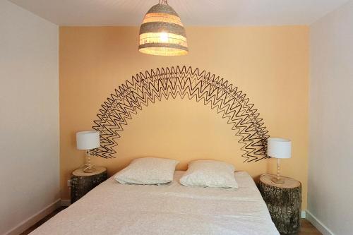 a bedroom with a large bed with two lamps at Maison Pierres Bois Feuilles in Alzon