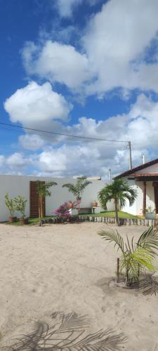 a building on the beach with palm trees in the sand at Pousada São Miguel Arcanjo in São Miguel do Gostoso