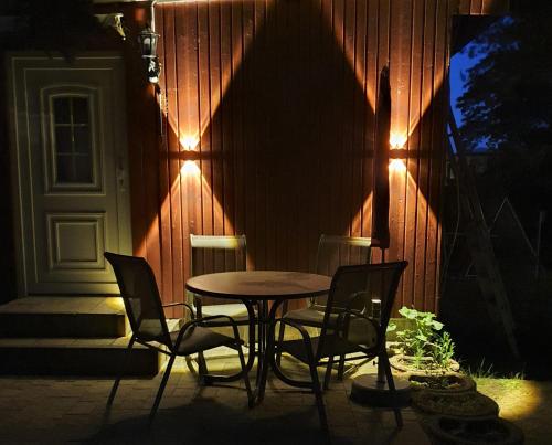 a table and chairs in front of a house with lights at Kölp - Will, Grit und Martin in Kolpinsee