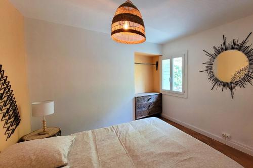 a bedroom with a bed and a mirror at Maison Pierres Bois Feuilles in Alzon