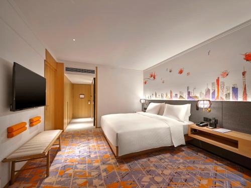 a hotel room with a bed and a flat screen tv at Hilton Garden Inn Guangzhou Tianhe-Free Shuttle Bus and Buyer Registration Available during Canton Fair Period in Guangzhou