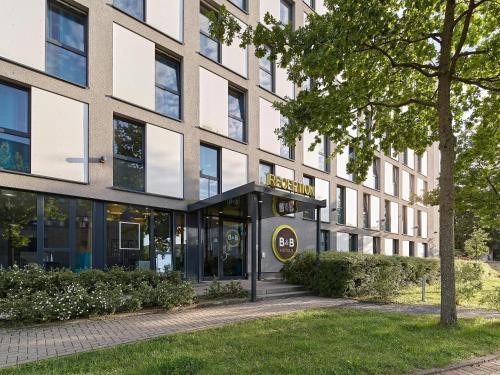 un bâtiment avec un panneau à l'avant dans l'établissement B&B Hotel Köln-Messe, à Cologne